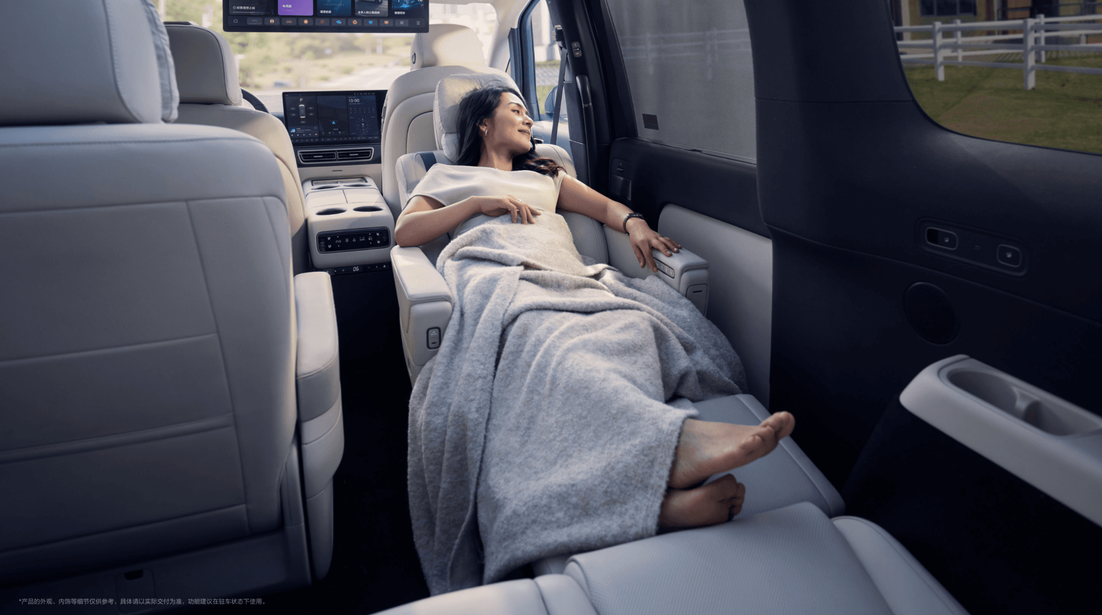 Woman reclining comfortably in a luxury vehicle's back seat, covered with a grey blanket.